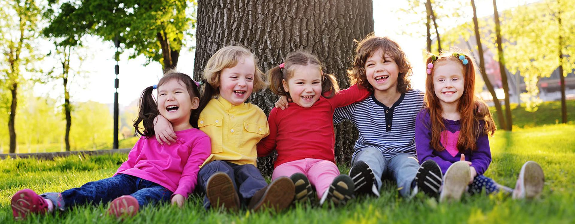 Kids sitting against tree