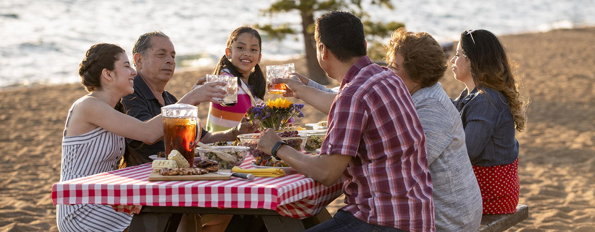 A family enjoys a beach BBQ on the shoreline of Lake Tahoe, NV